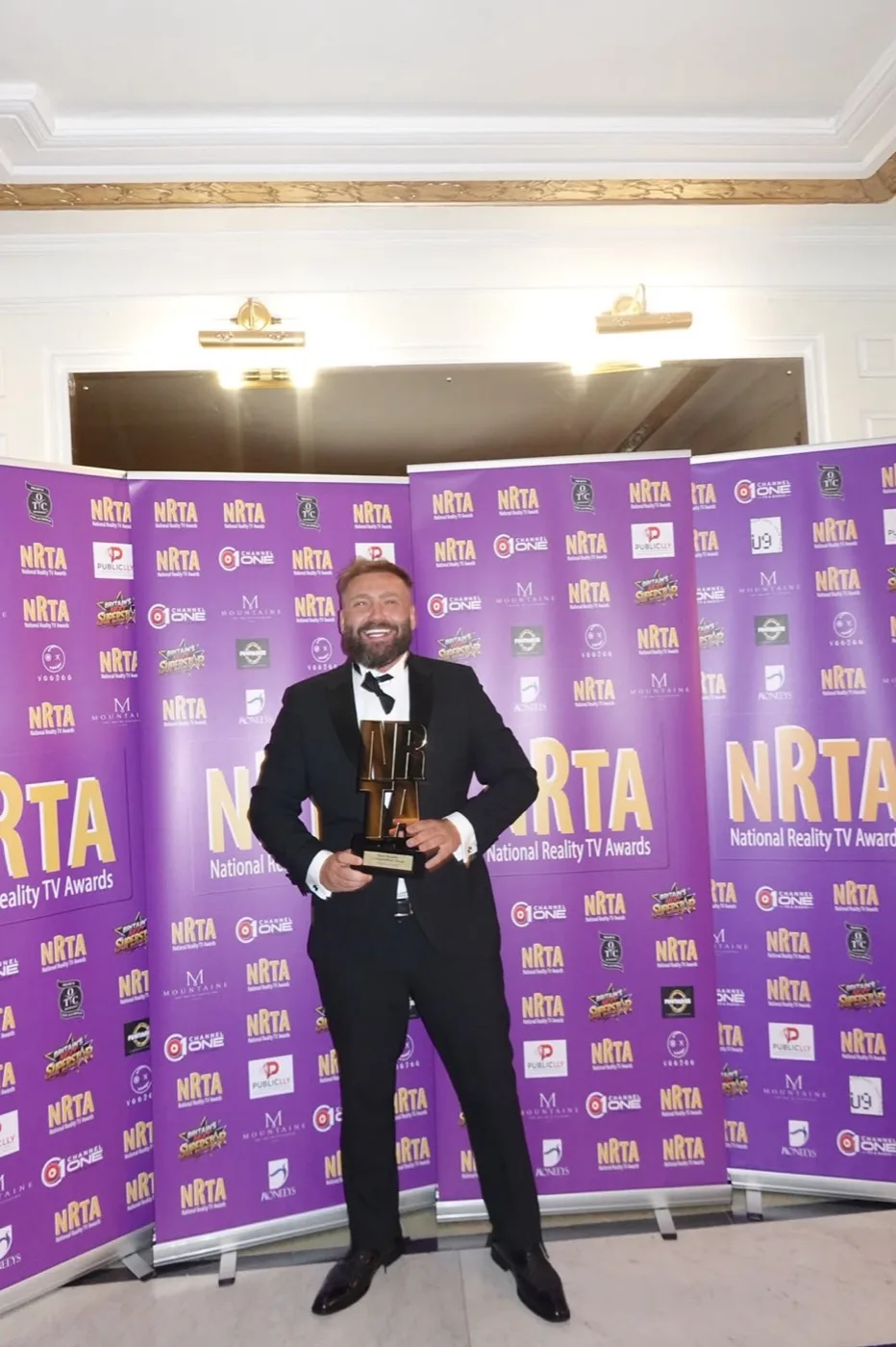 Shaun Docherty holding his National Reality TV Award for The Summit